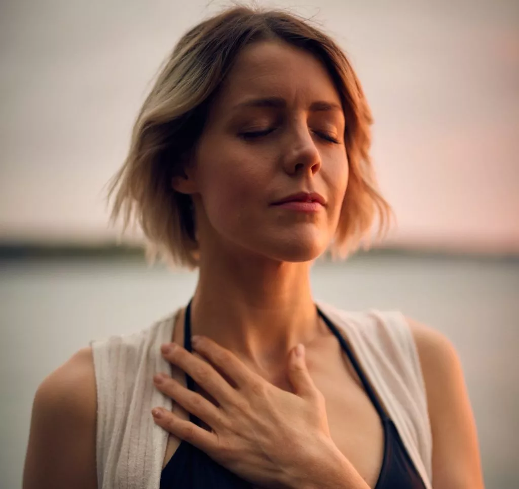 Photo d'une femme avec la main sur le coeur en plan serré sur le visage.
